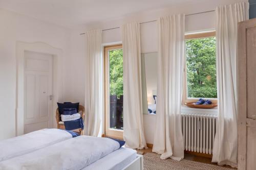 um quarto com 2 camas e uma grande janela em Fewo im Blauen Haus Dg em Garmisch-Partenkirchen