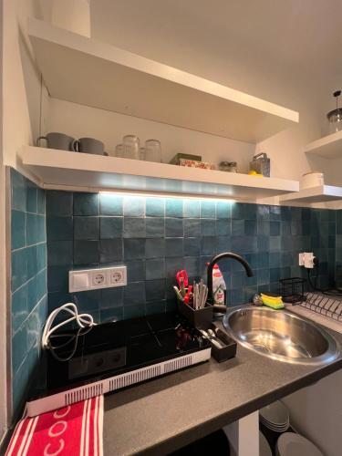 um balcão de cozinha com um lavatório e um fogão em Sparkling Time Apartman em Hajdúszoboszló
