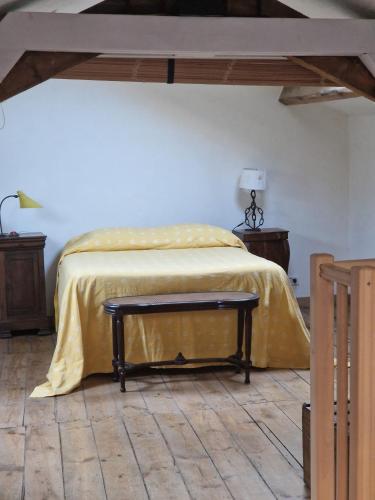 a bedroom with a bed with a yellow blanket on it at La maison du vigneron in Auzon