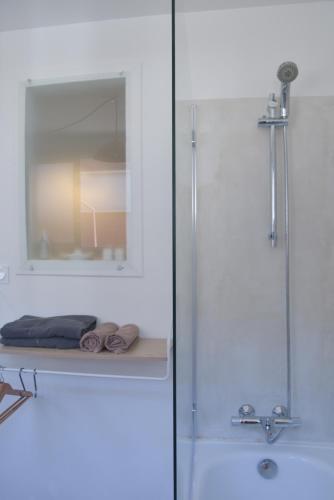 La salle de bains est pourvue d'une douche et d'un lavabo avec un miroir. dans l'établissement L'Annexe du Bivouac, à Toulouse