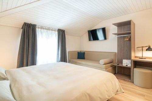 - une chambre avec un lit, un canapé et une fenêtre dans l'établissement Relais Lucomagno, à Olivone