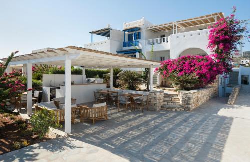 a patio with tables and chairs under a pergola at KAMEO, Antiparos in Antiparos