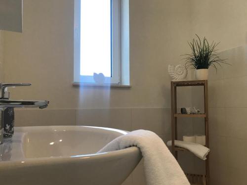 a bathroom with a white tub and a window at Das Haus am See in Marienfelde