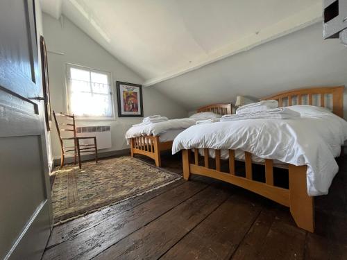 a bedroom with two beds and a window at Maison de la Calonne - Riverside house & terrace in Cormeilles