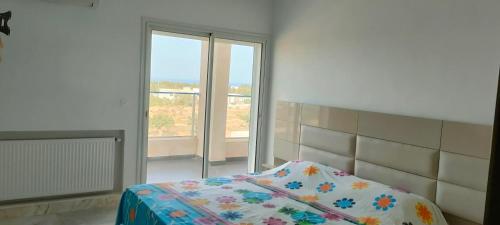a bedroom with a bed and a large window at Appartement Haut Standing à Hammamet - Tunisie in Hammamet
