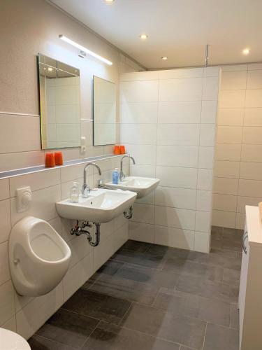 a bathroom with two sinks and a toilet and a urinal at Beilsteiner Gästehaus in Beilstein