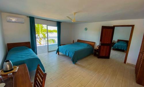 1 dormitorio con 2 camas, mesa y espejo en Orangea Beach Resort, en Andilana