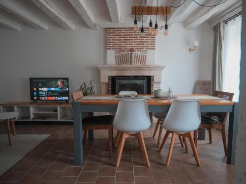 a dining room with a table and chairs and a fireplace at La Ferme Étoilée in Valençay