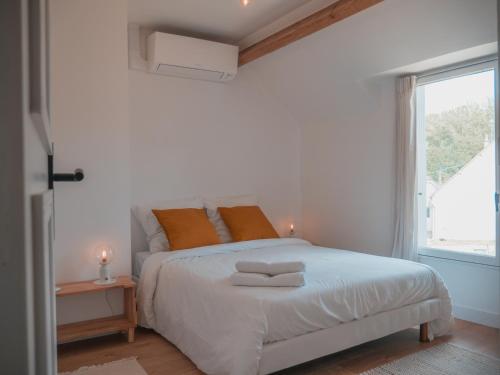 a white bedroom with a bed and a window at La Ferme Étoilée in Valençay