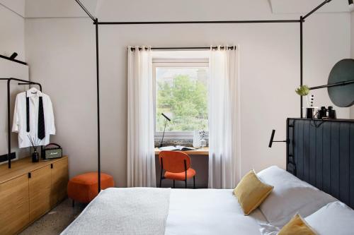 a bedroom with a bed and a desk and a window at Laqua Countryside in Vico Equense