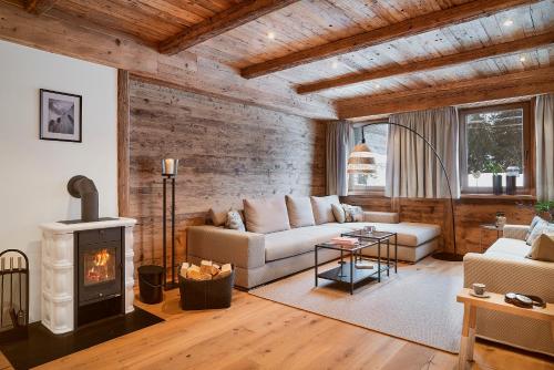 a living room with a couch and a fireplace at Berghaus Schröcken - Hotel Apartments Spa in Schröcken