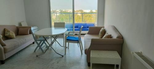 a living room with a couch and a table and chairs at Appartement Haut Standing à Hammamet - Tunisie in Hammamet