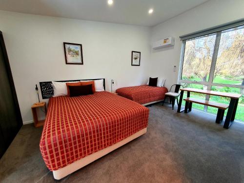 1 dormitorio con 2 camas, mesa y ventana en Port Arthur Villas en Port Arthur