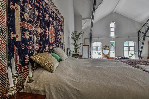 1 dormitorio con 1 cama grande y tapiz en Badacsony Loft, en Badacsonytomaj