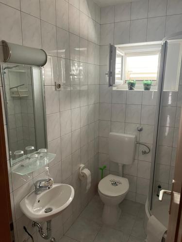 ein weißes Bad mit einem WC und einem Waschbecken in der Unterkunft Haus Grace in Kaštela