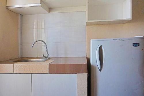 eine Küche mit einer Spüle und einem Kühlschrank in der Unterkunft Collection O GLV Tower B in Tangerang