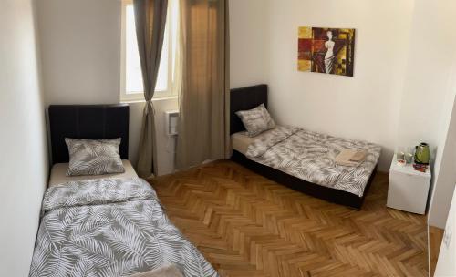 a room with two beds and a window at Apartmani Home in Zaječar