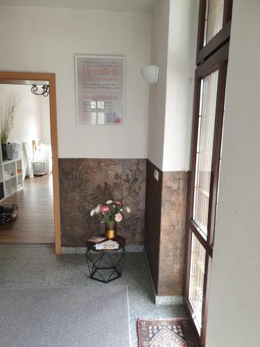 a hallway with a table with flowers on it at Gasthof und Pension Hammerschänke in Wildenthal