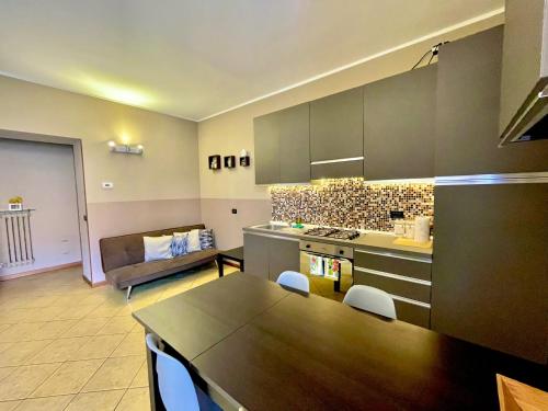 a kitchen with a table and a couch in a room at CASA DI MIRCO - AMPIO E MODERNO BILOCALE in Castenedolo