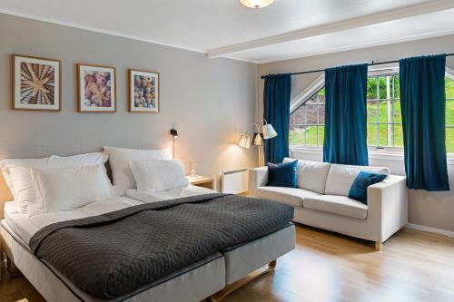 - une chambre avec un lit, un canapé et une fenêtre dans l'établissement Moens Motell, à Fiskå