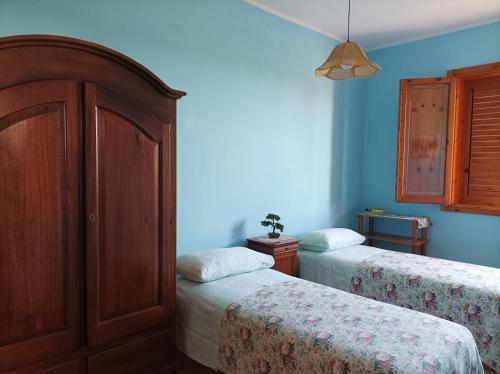 two beds in a room with blue walls at Dimora Relax in Torre dell'Orso