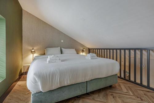 a bedroom with a large bed with white sheets at Bens The Walton in Amsterdam