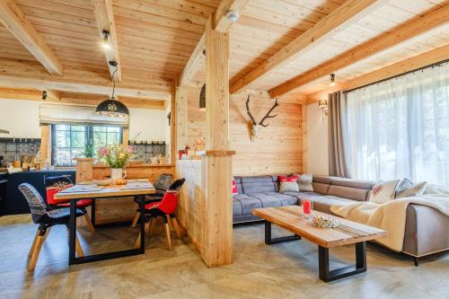 ein Wohnzimmer mit einem Sofa und einem Tisch in der Unterkunft Villa Capra - Apartments Adult Only in Zakopane