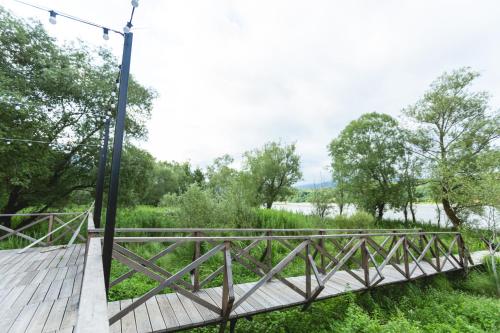a wooden bridge over a field with trees at Porto Gumati in Kutaisi