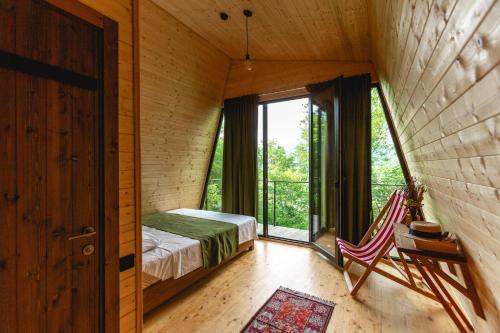 a room with a bed and a window and a chair at Porto Gumati in Kutaisi