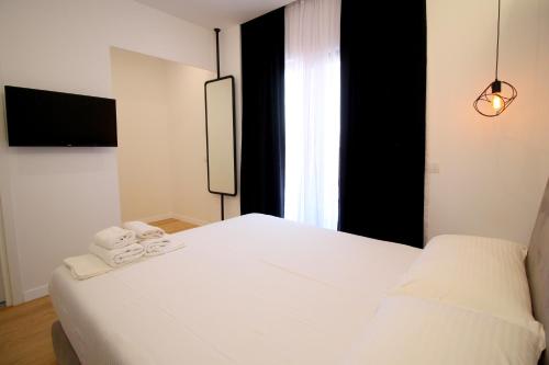 Un dormitorio con una cama blanca con toallas. en Hotel Qurku 2, en Sarandë