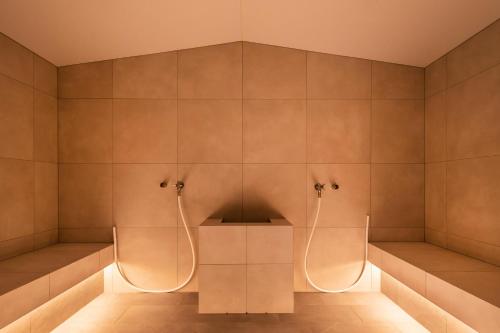 a bathroom with a shower with two siphons at Berghaus Schröcken - Hotel Apartments Spa in Schröcken