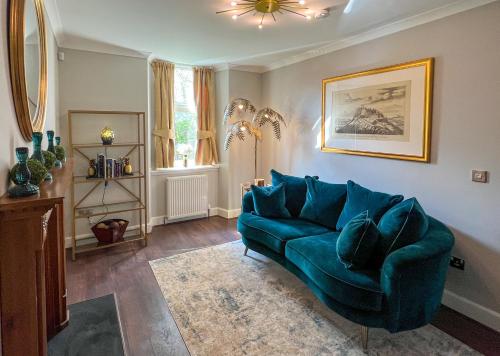 een woonkamer met een blauwe bank en een raam bij Luxury Pitlochry Retreat- Cairngorms Ntl Park Gateway in Pitlochry