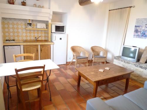 a living room with a table and chairs and a kitchen at Le Lavoir in Lacoste