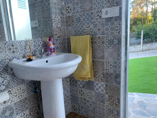 a bathroom with a white sink and a shower at Casa de piedra, A Lameira in A Coruña