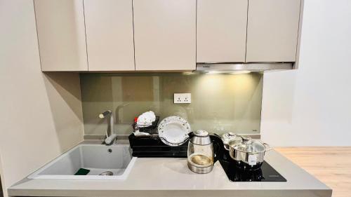 a kitchen with white cabinets and a sink at The Song Luxury Condotel Vung Tau - Căn hộ cao cấp Luca's House in Vung Tau