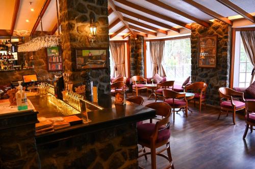 a bar in a restaurant with chairs and tables at The Carlton Kodaikanal in Kodaikānāl
