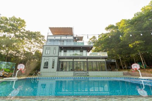 a house with a swimming pool in front of it at Cung Mây Villas - Venue Travel in Ba Vì