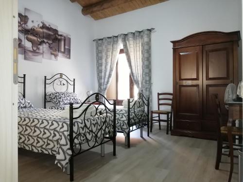 een slaapkamer met 2 bedden en een raam bij Bed And Breakfast Polizzi House in Petralia Sottana
