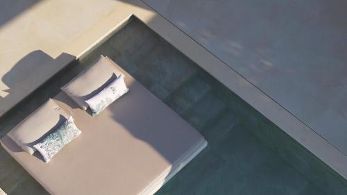 un riflesso di due cuscini su un tavolo in piscina di Epiphany Villas Lefkada a Tsoukalades