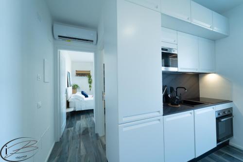 a kitchen with white cabinets and a stove top oven at I Bordin Home in Nettuno