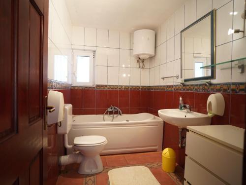 a bathroom with a tub and a toilet and a sink at Sea House Mljet in Polače