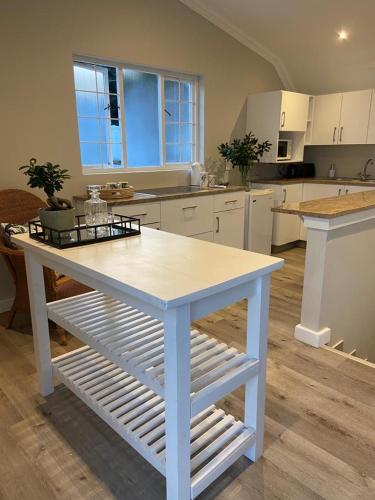 ダーバンにあるThe Loft on Monteithの白いテーブル付きのキッチンが備わる客室です。
