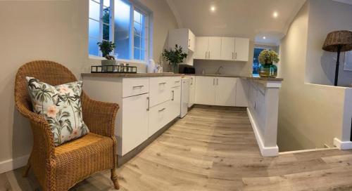 a kitchen with white cabinets and a wooden floor at The Loft on Monteith in Durban