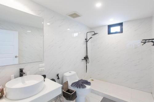 a white bathroom with a sink and a mirror at patong sunset villa Phuket in Patong Beach