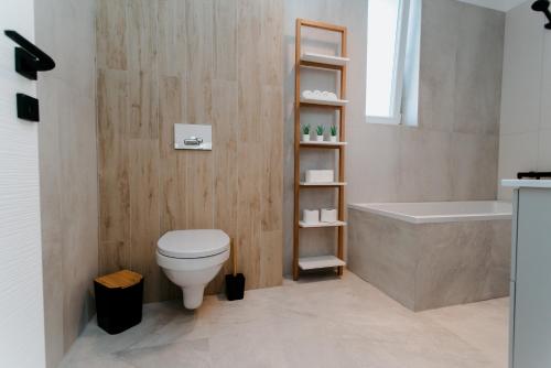 a bathroom with a white toilet and a bath tub at Evo Residence Taietura Turcului in Cluj-Napoca
