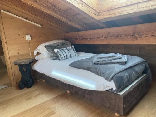Cama en habitación con techo de madera en Chalet Moose en Morzine