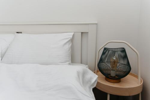 a bedroom with a white bed and a lamp on a table at Evo Residence Taietura Turcului in Cluj-Napoca