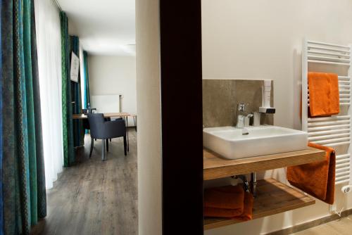 uma casa de banho com um lavatório e uma mesa em Hotel Zum Grünen Baum em Pfahlheim