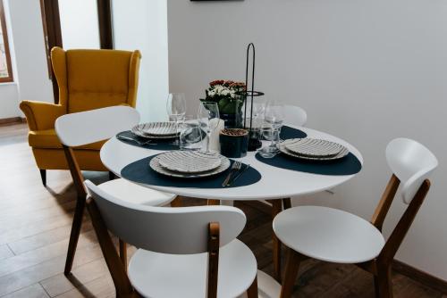 a dining room with a white table and chairs at Evo Residence Taietura Turcului in Cluj-Napoca