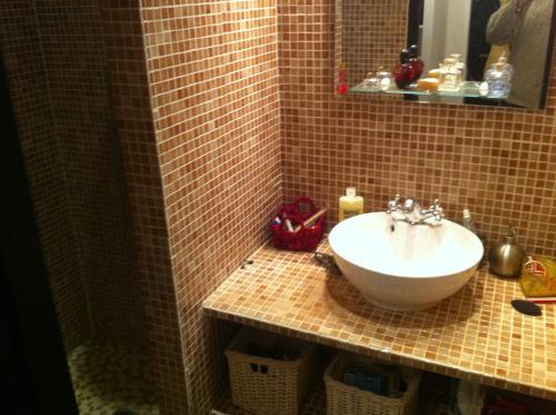 une salle de bains avec un lavabo et un miroir dans l'établissement La Cathare, à Lézignan-Corbières